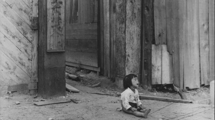 small South Korean child sitting alone in street after battle in the city of Inchon in September 1950